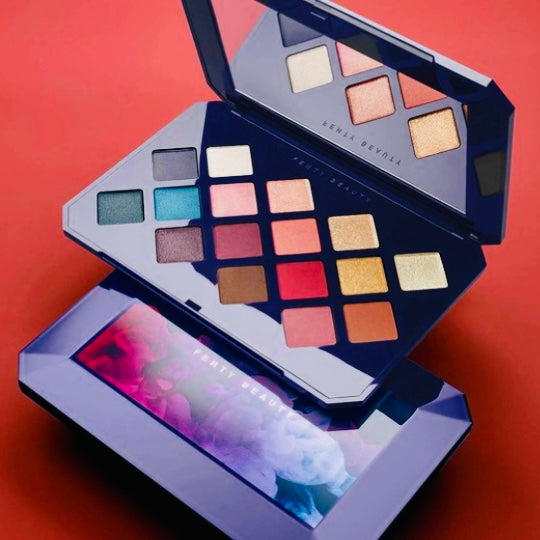 This photo is showing two Fenty BEAUTY limited edition Moroccan 16 color high pigment eyeshadow palette with built in mirror with one moroccan eyeshadow palette open, displaying eyeshadow colors while sitting on top of a identical eyeshadow palette that’s closed, these 2 products are displayed for photo optics.