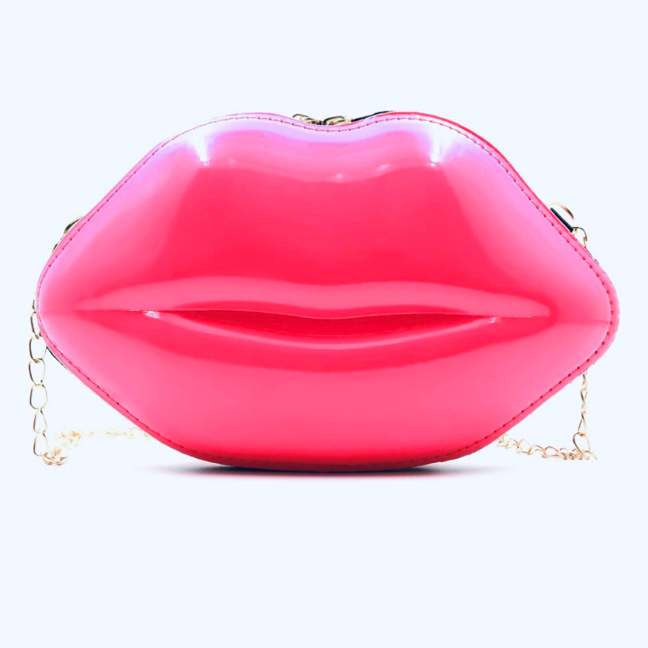 Hot pink lip handbag with gold accent shoulder chain on display