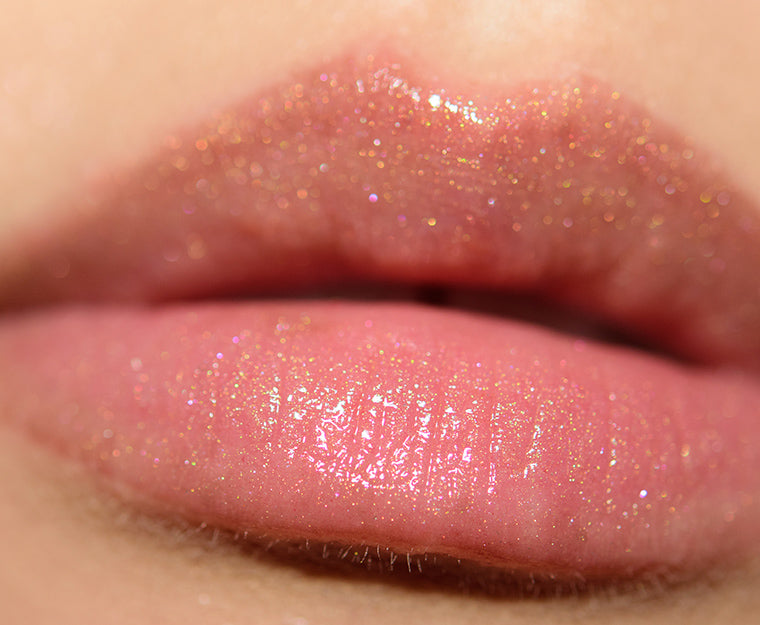 This Lip Gloss Is A very warm-toned, light-medium Tan (Soft Brown) with a hint of Peach pearl finish. It is a sheer lip-gloss that not sticky and goes on smooth and with ease. The 3D light-reflecting pigments as well as Ginger, Peppermint oil, and a non-stinging peptide make lips appear fuller and smoother. Contains Vitamins C and Vitamin E, plus hydrating Shea Butter and Muru Muru Butters to soften, protect and condition the lips. Becca Champagne Cocktail Lip Gloss shade "Bellini"