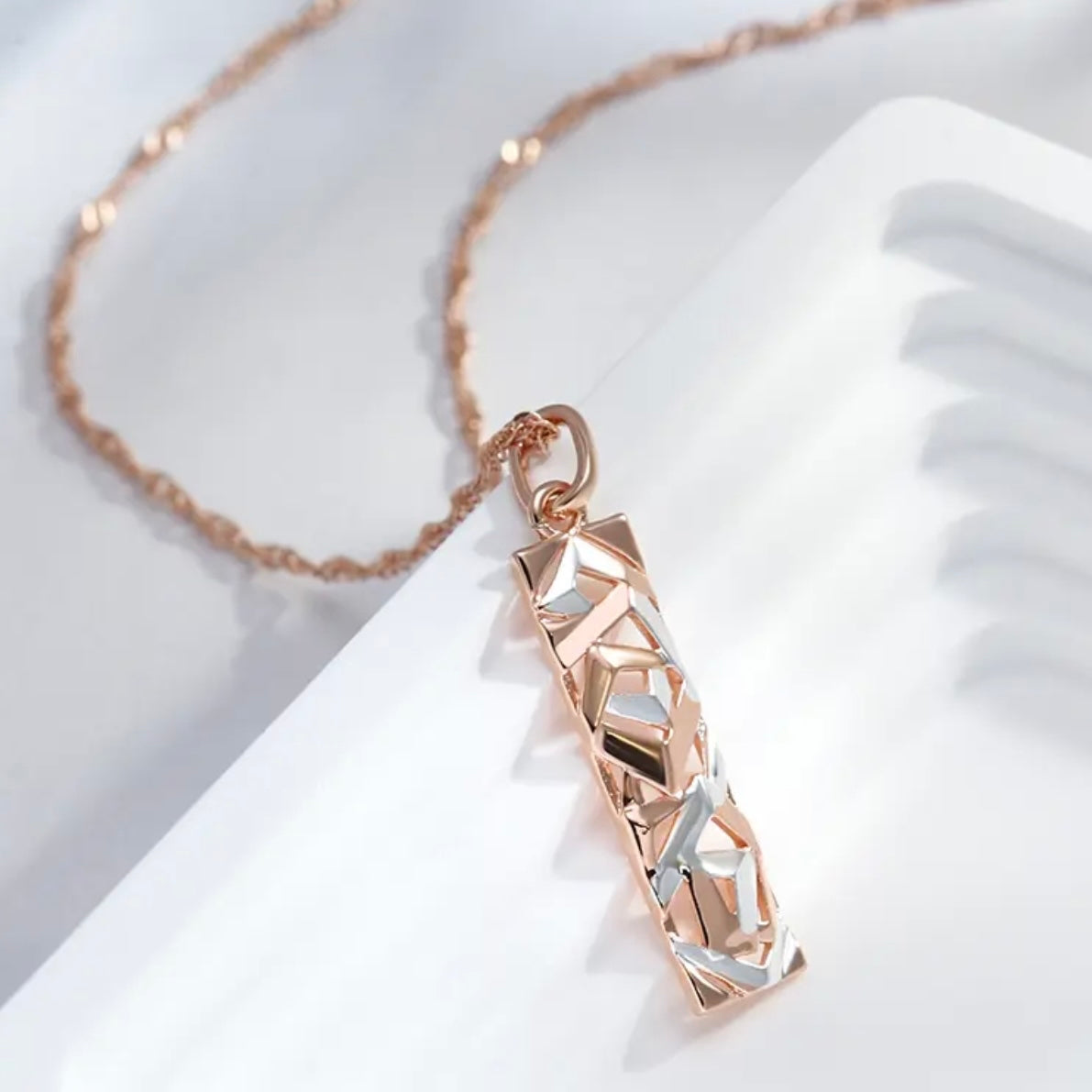 This Sterling Silver, Rose Gold, and High-grade Steel tricolor necklace and earrings set is perfect for any special woman in your life. Crafted with expertly sourced top-grade steel and silver material, these pieces are timeless and sure to make a lasting impression. The pendant is a twisted-rectangle shape adorned with dazzling sparkles, while the 18-inch link-style necklace complements with a bold yet elegant look. Matching tricolor earrings complete the set - perfect for any occasion! 