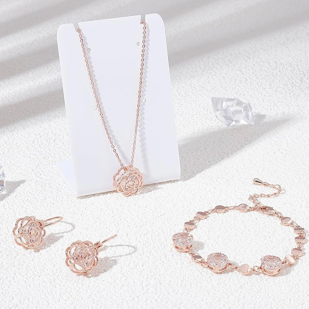 Rose gold jewelry set including necklace, earrings, and bracelet on a white background