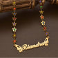 customizable 17 inch flower necklace with customizable name plate with stainless steel and gold butterfly wings encrusted with multicolored sapphire gemstones through each flower which creates the necklace, great gift for all ages and made for sensitive skin.
