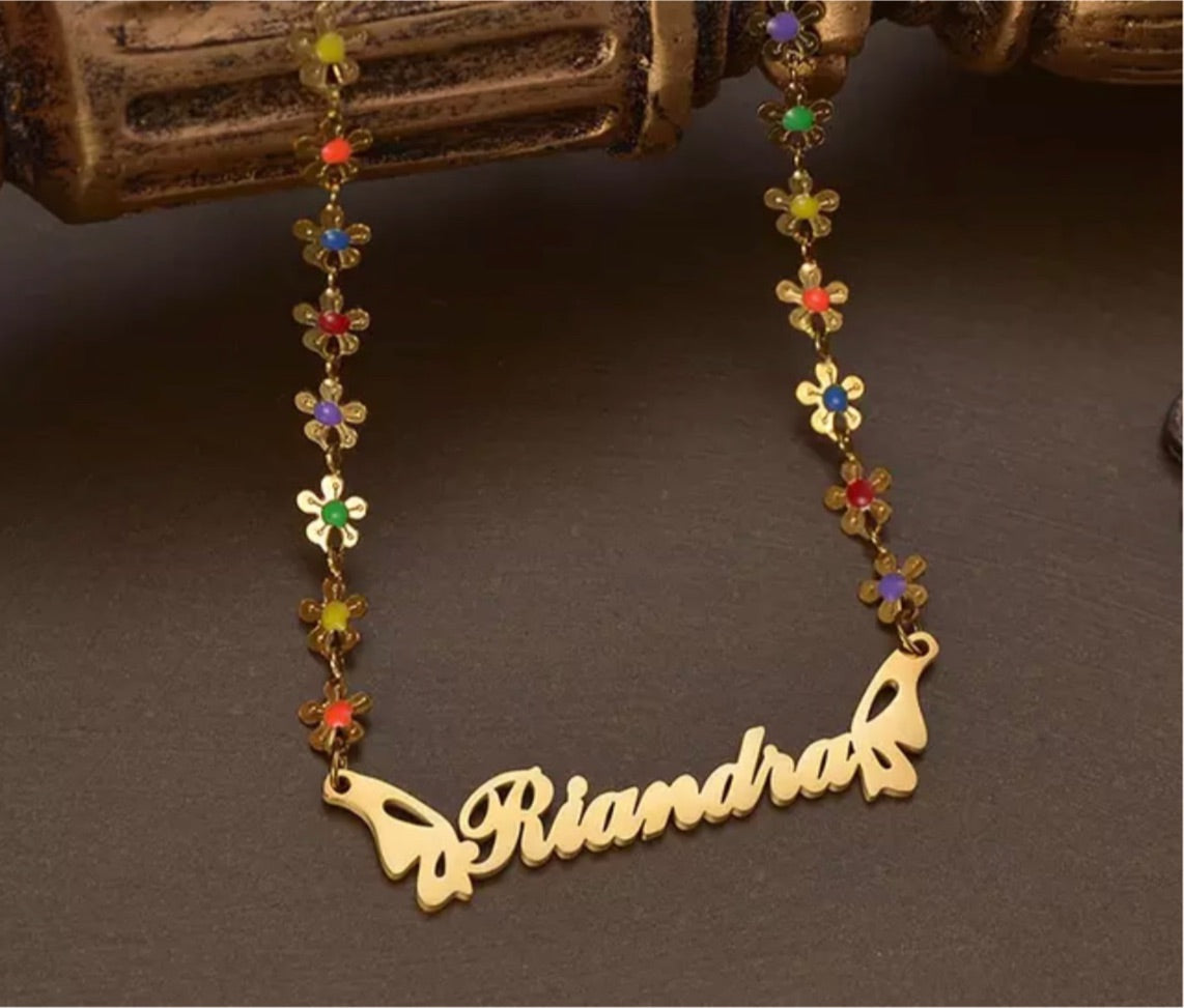customizable 17 inch flower necklace with customizable name plate with stainless steel and gold butterfly wings encrusted with multicolored sapphire gemstones through each flower which creates the necklace, great gift for all ages and made for sensitive skin.
